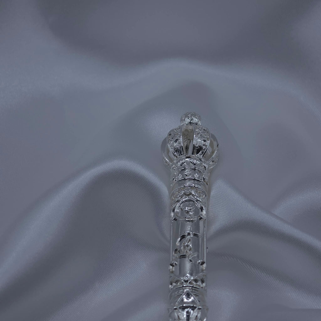 Macro detail of the filigree crown of the  back of the Moriah Cross Works Bible Reading Pointer in bright mirror-polished silver, showing the intricate lattice and scrollwork of the Ionic capital