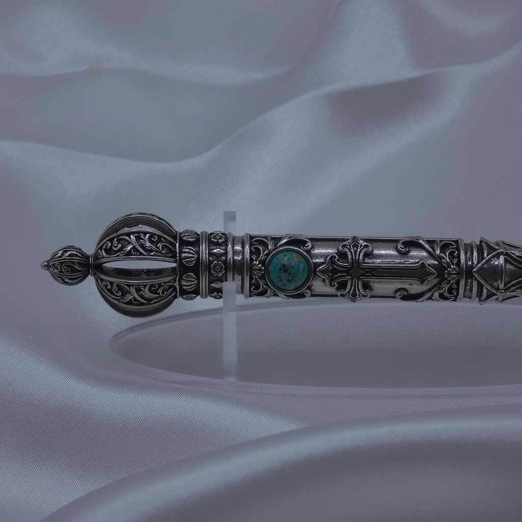 Close-up detail of the filigree crown and upper shaft of the Moriah Cross Works Bible Reading Pointer in antiqued silver, showing deep shadow contrast between the raised ornaments and recessed background, with King Solomon Stone set below the crown