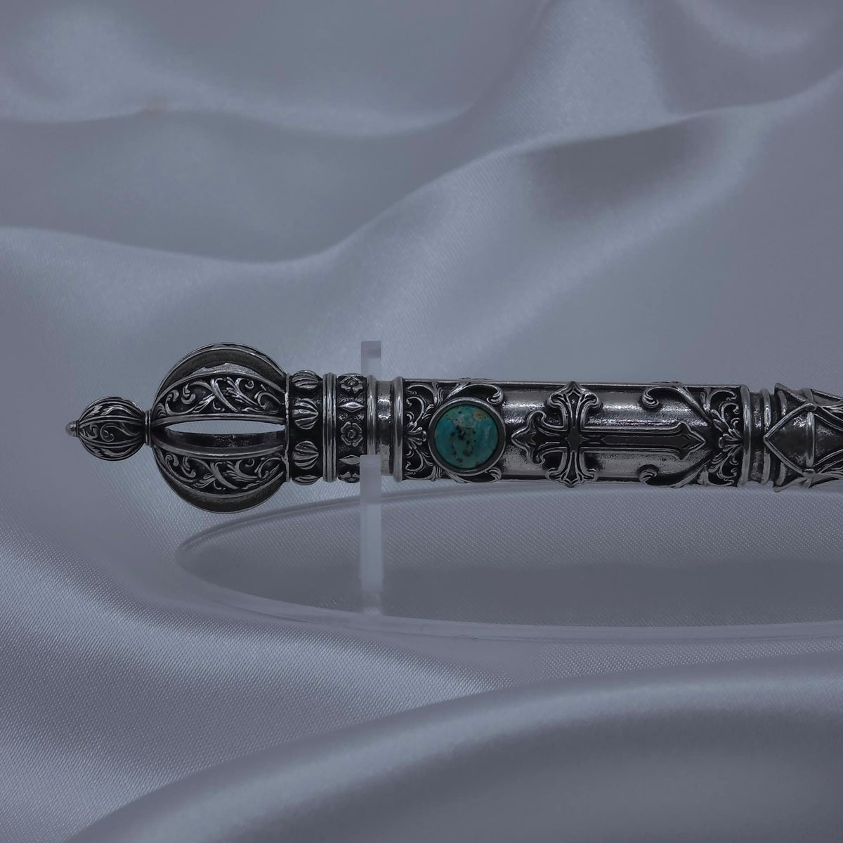 Close-up detail of the filigree crown and upper shaft of the Moriah Cross Works Bible Reading Pointer in antiqued silver, showing deep shadow contrast between the raised ornaments and recessed background, with King Solomon Stone set below the crown