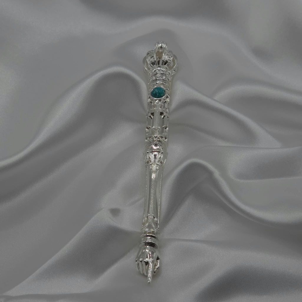 The Moriah Cross Works BR-BRSP-001 Bible Reading Pointer in bright mirror-polished silver, full length view showing the ornate crown, filigree shaft, and pointing hand, resting on white satin