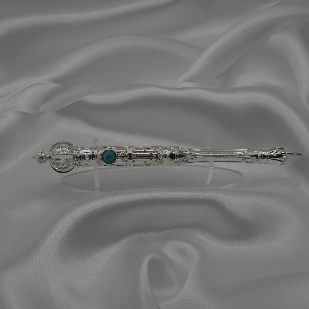 The Moriah Cross Works BR-BRSP-001 Bible Reading Pointer in bright silver displayed horizontally on grey silk, showing the full length of the piece with the King Solomon Stone cabochon and ornate pointing hand visible