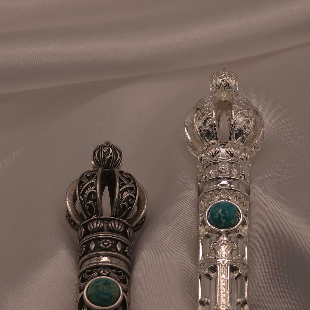 Close-up comparison of the filigree crowns of the two Moriah Cross Works Bible Reading Pointer samples, antiqued silver on the left and bright silver on the right, showing the contrast between the two finishing treatments