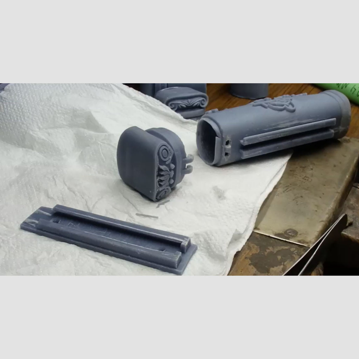 3D printed grey resin prototype components of doorpost scripture holder showing top cap, body cylinder, and backplate parts prior to assembly